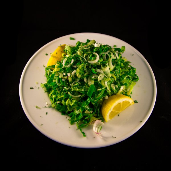 Green salad with onions and lemon on the side
